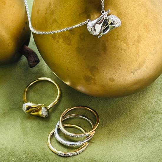 Lifestyle image of diamond stackable bands with Pear-adigm Shift necklace and ring set by Pavé The Way® Jewelry