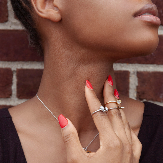 Model wears Equal To The Core gold-plated Apple ring with stackable rings by Pavé The Way® Jewelry